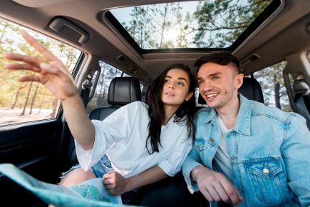 casal-medio-em-carro-com-mapa_23-2148637394